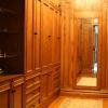 This Walk-In closet made from Red Oak and Natural Maple interiors features matching paneled walls, drawer base cabinets, roll out hampers, plenty of clothes hanging space, adjustable shelving and shoe cubbies.Also, a full length mirror, open glass shelf cabinet & pull out folding area. 