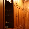 This Walk-In closet made from Red Oak and Natural Maple interiors features matching paneled walls, drawer base cabinets, roll out hampers, plenty of clothes hanging space, adjustable shelving and shoe cubbies.Also, a full length mirror, open glass shelf cabinet & pull out folding area. 