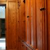 This Walk-In closet made from Red Oak and Natural Maple interiors features matching paneled walls, drawer base cabinets, roll out hampers, plenty of clothes hanging space, adjustable shelving and shoe cubbies.Also, a full length mirror, open glass shelf cabinet & pull out folding area. 