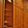 This Walk-In closet made from Red Oak and Natural Maple interiors features matching paneled walls, drawer base cabinets, roll out hampers, plenty of clothes hanging space, adjustable shelving and shoe cubbies.Also, a full length mirror, open glass shelf cabinet & pull out folding area. 